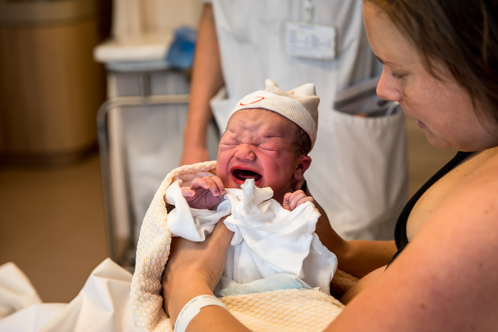 Een pasgeboren baby tijdens een geboortereportage