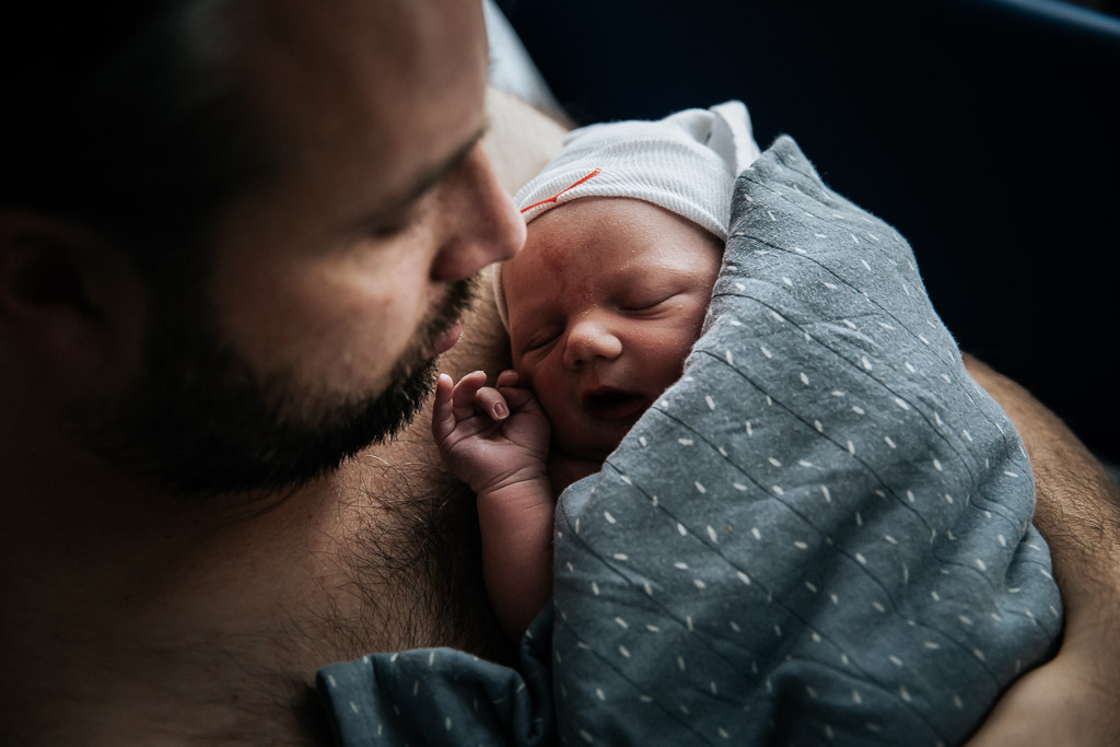 Pasgeboren baby bij papa op de borst
