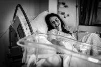 De moeder blijft verliefd naar haar pasgeboren dochter kijken