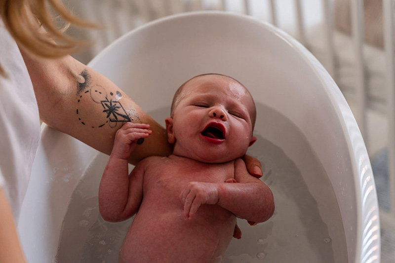 Kraamreportage-Purmerend-3 Tijdens een lifestyle kraamreportage wordt de baby in bad gedaan door de mama