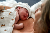 Geboortereportage Veenendaal-19 Een pasgeboren baby ligt warm tegen de borst van de moeder, een intiem moment dat ik als geboortefotograaf graag vastleg.