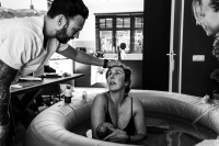 Geboortereportage Veenendaal-9 Mama kijkt vol ongeloof naar papa nadat hun dochter net thuis geboren is in bad