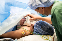 Papa en mama bewonderen hun kindje na de keizersnede