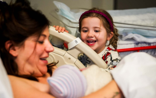 Het oudere zusje is dolblij als ze haar pasgeboren broertje ziet in het RKZ ziekenhuis Beverwijk