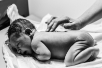 De verloskundige kijkt de baby na na de VBAC geboorte