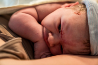 Geboortefotografie Haarlem-7 De baby heeft honger en begint op zijn handje te sabbelen