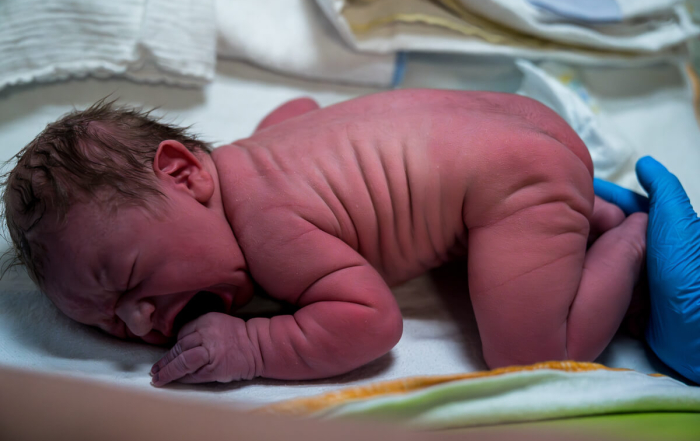De baby wordt na de bevalling nagekeken door de verloskundige