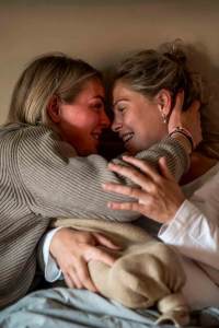 Geboortereportage-Hoorn-21 Een lieve foto van tweelingzussen die elkaar omhelzen nadat de baby is geboren